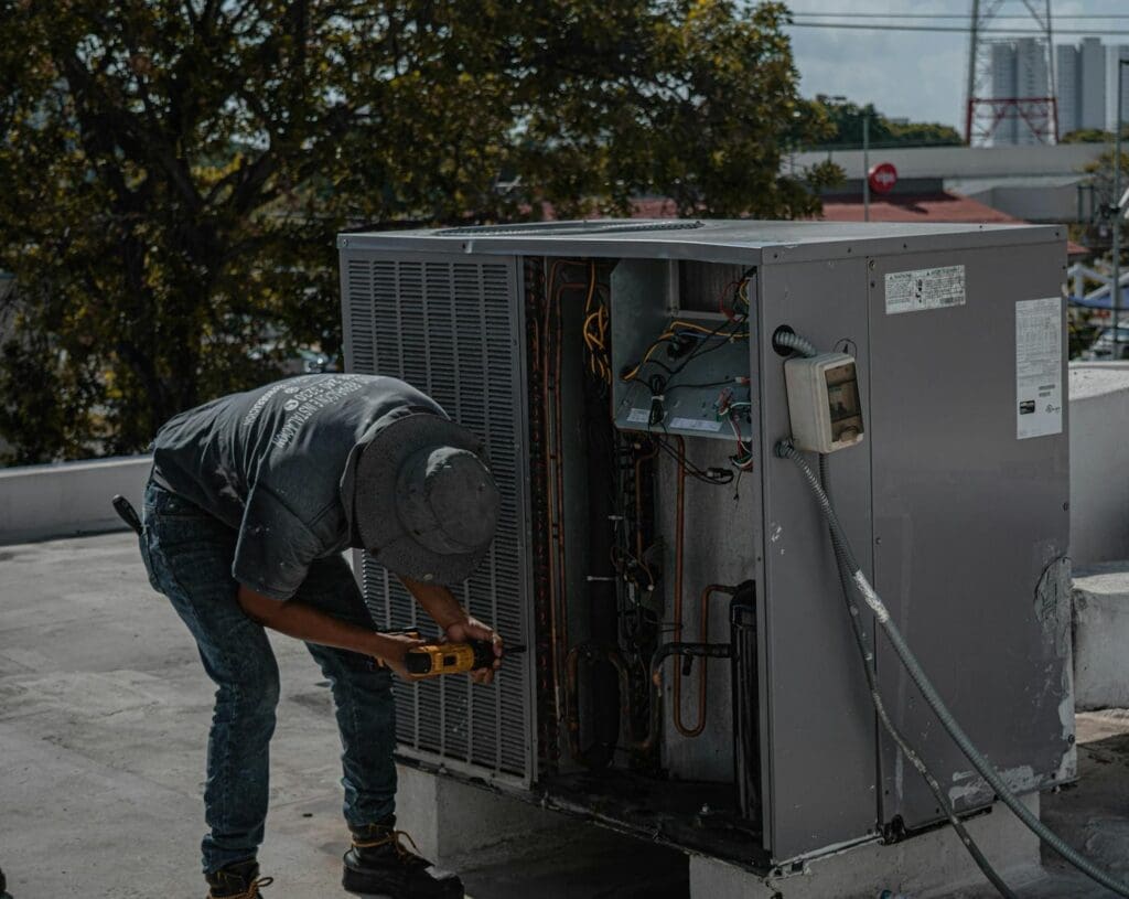 A technician is repairing an air conditioning unit on a rooftop, Fan Not Running